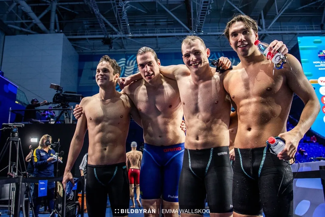 Daniel with fellow swimmers beside the pool.